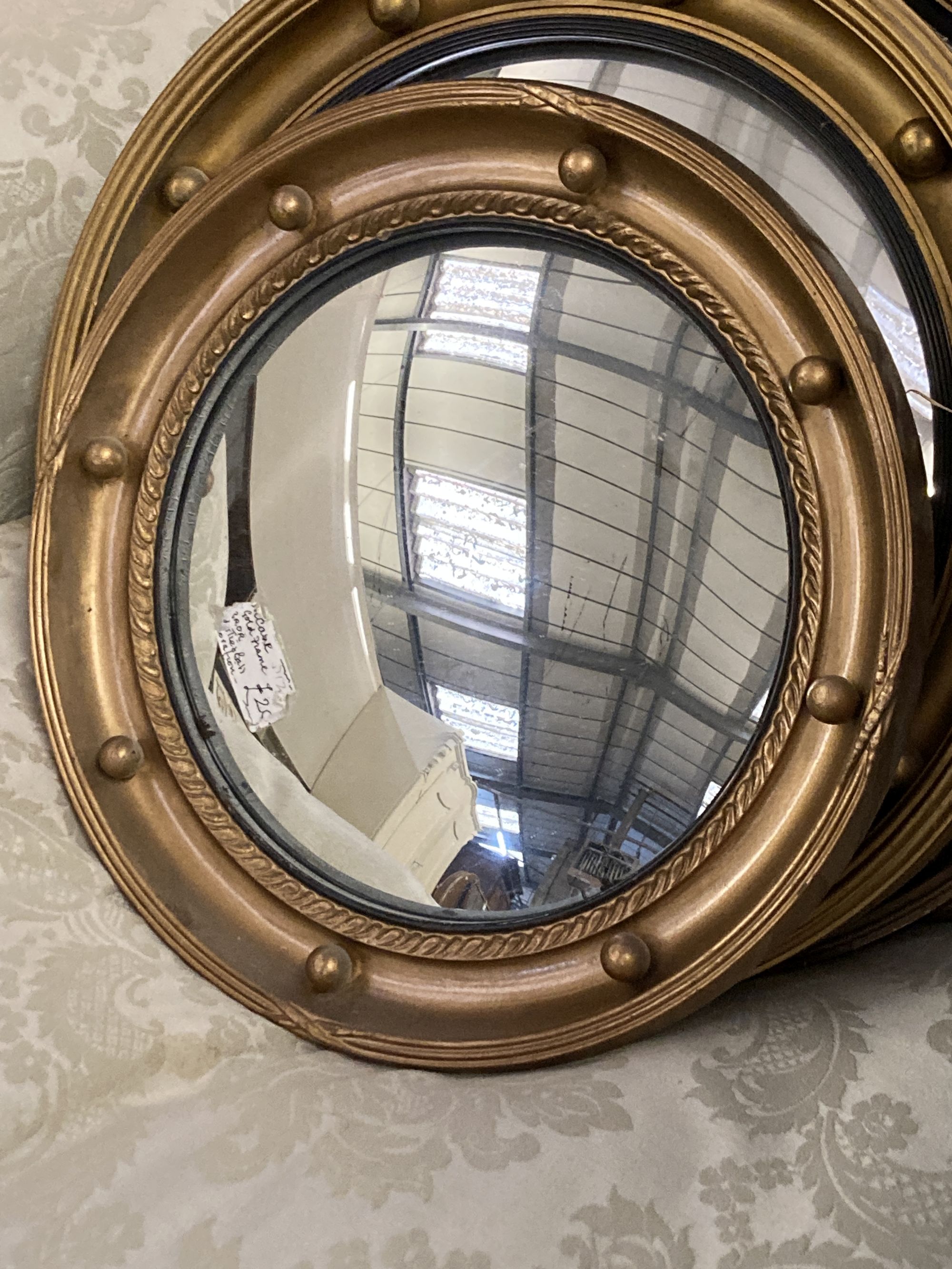 Four circular gilt framed convex and wall mirrors, largest 50cm diameter